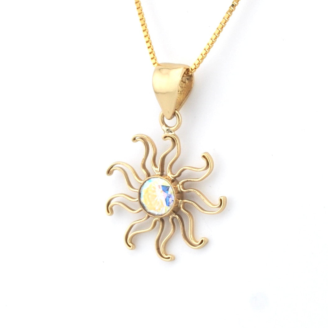 Gold sun-shaped pendant necklace on a white background