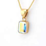 Gold necklace with a rectangular pendant on a white background