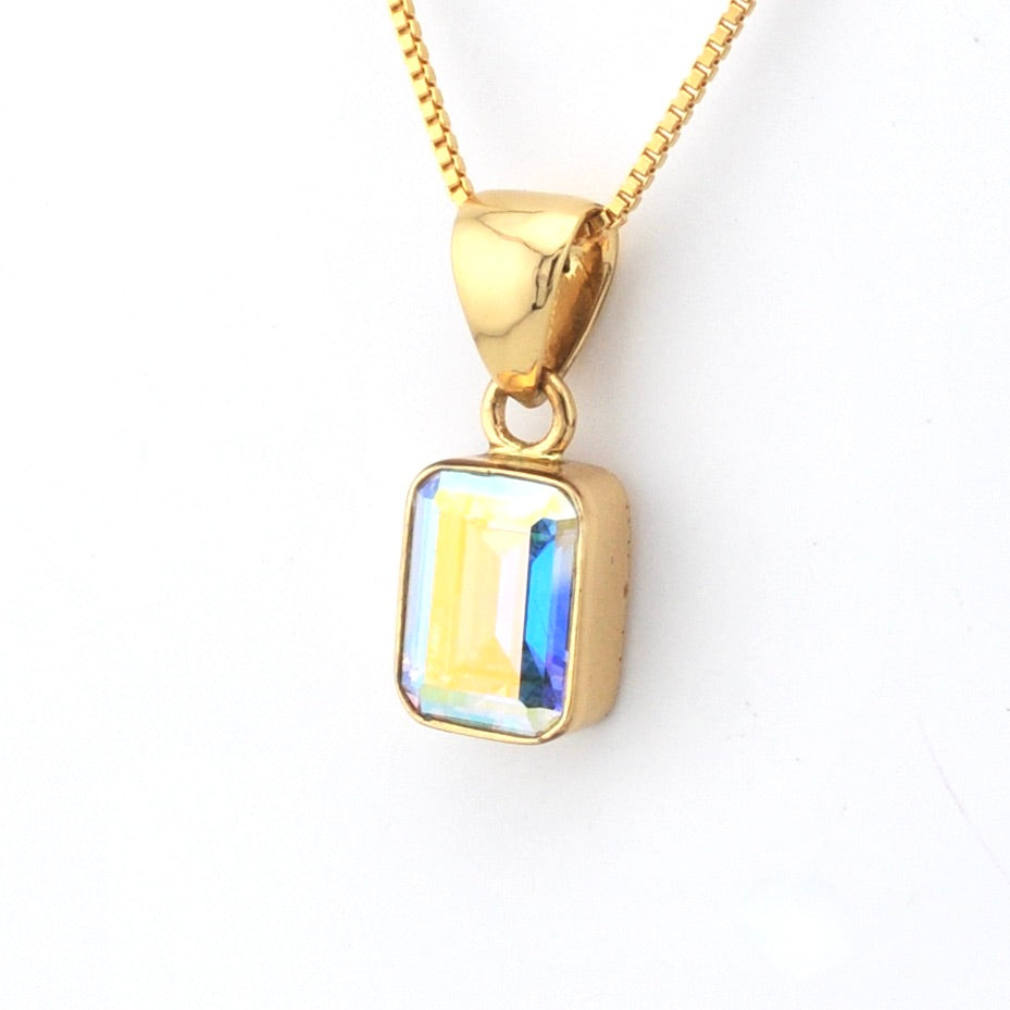 Gold necklace with a rectangular pendant on a white background