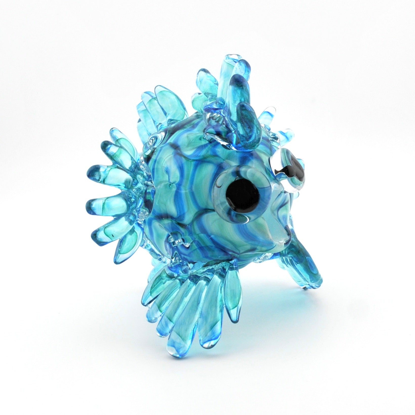Glass fish figurine with blue and clear patterns on a white background