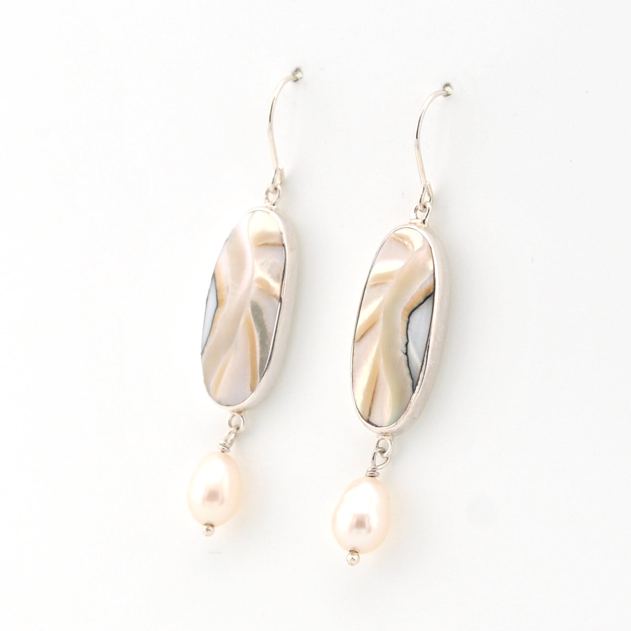 Pair of earrings with shell and pearl elements on a white background