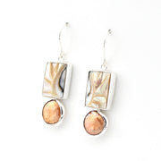 Pair of earrings with marbled stone drops on a white background