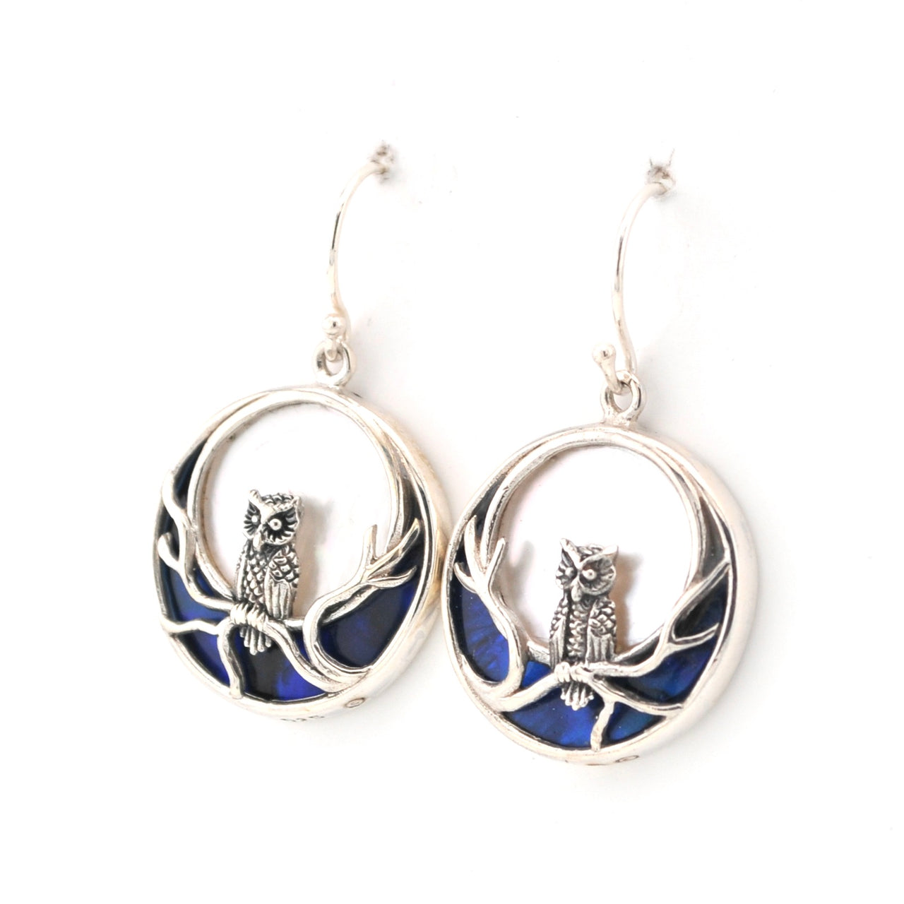 Silver earrings with owl designs on a white background
