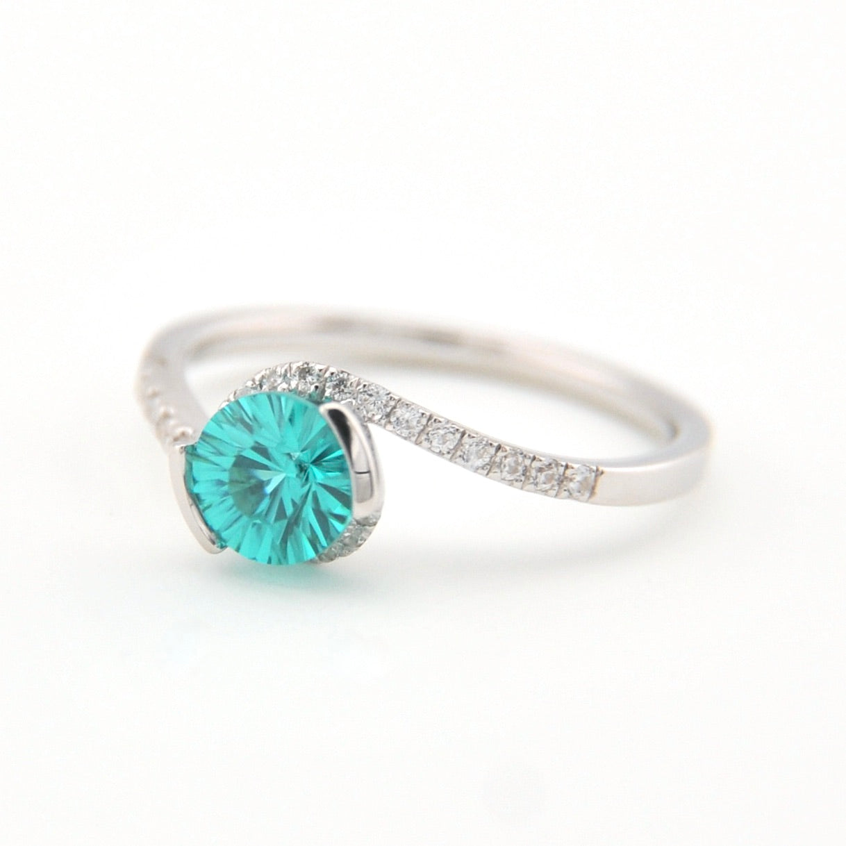 Silver ring with a teal gemstone on a white background