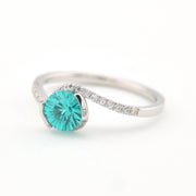Silver ring with a teal gemstone on a white background
