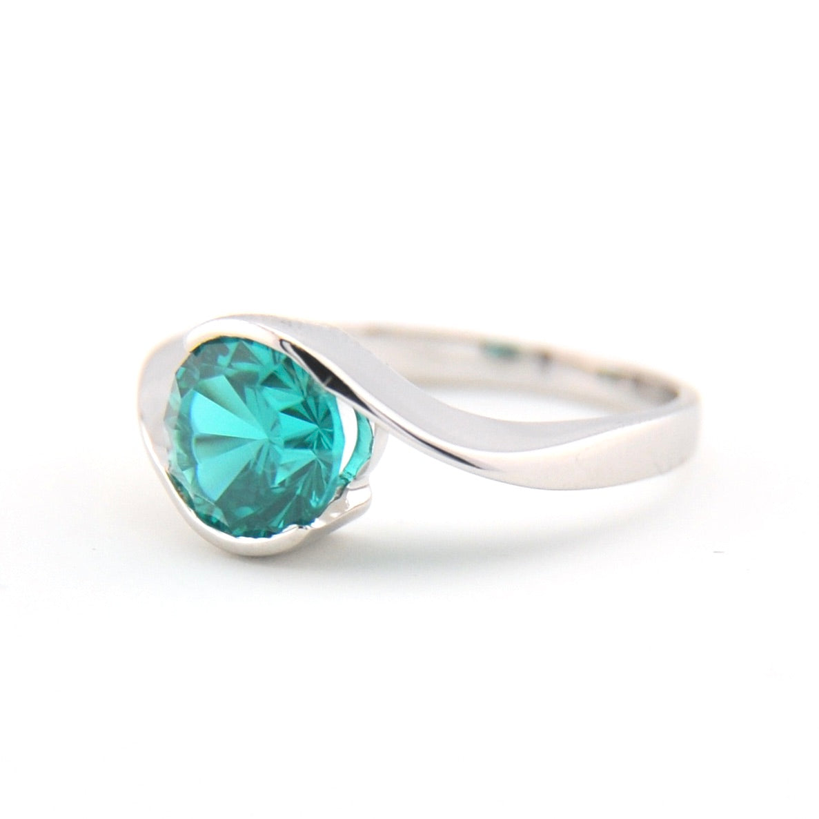 Silver ring with a green gemstone on a white background
