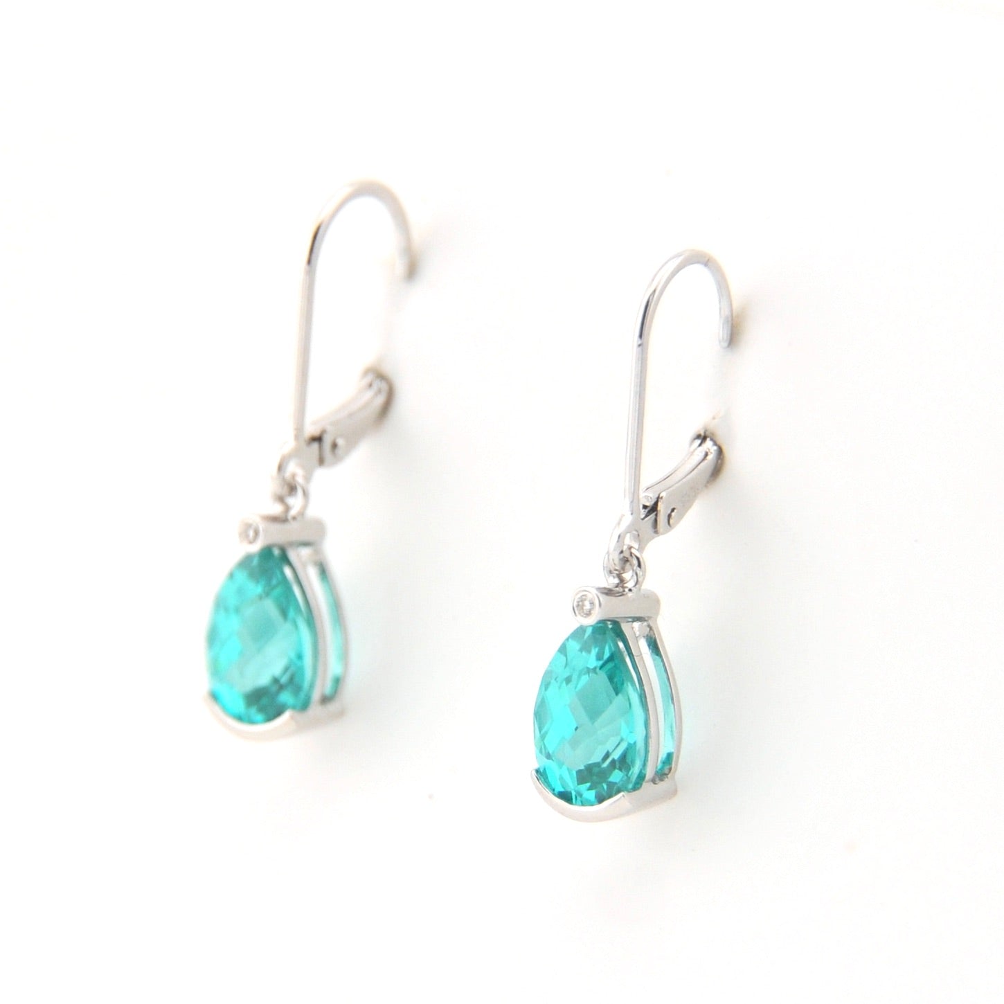 Pair of earrings with teal teardrop stones on a white background