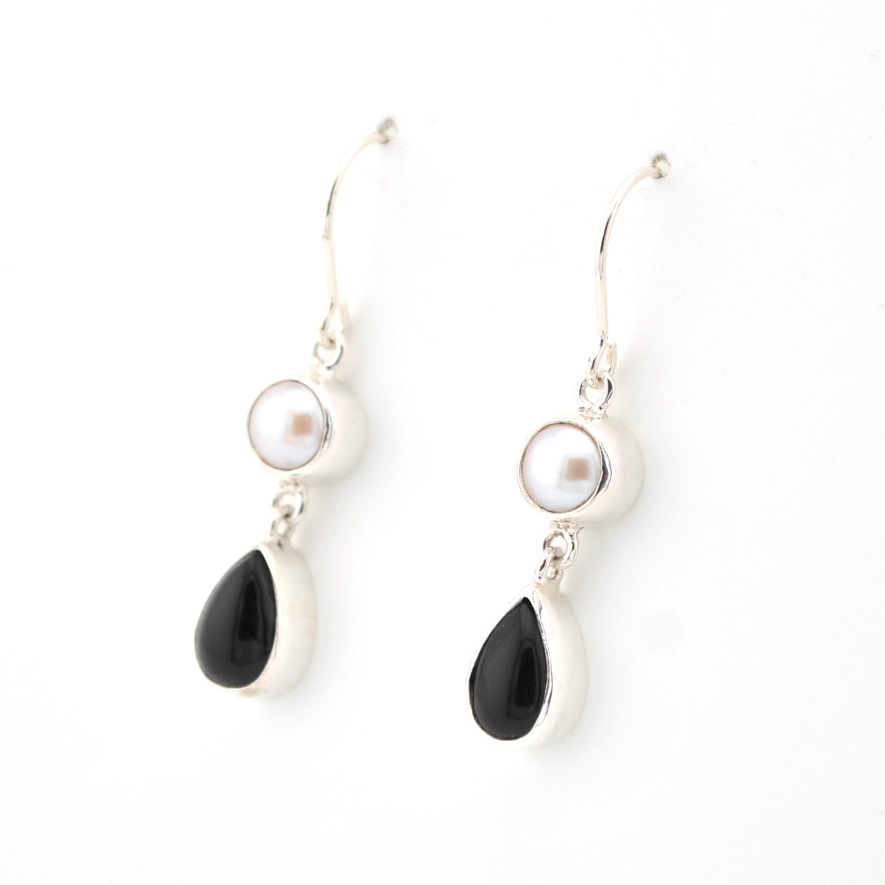Pair of earrings with black teardrop and pearl elements on a white background