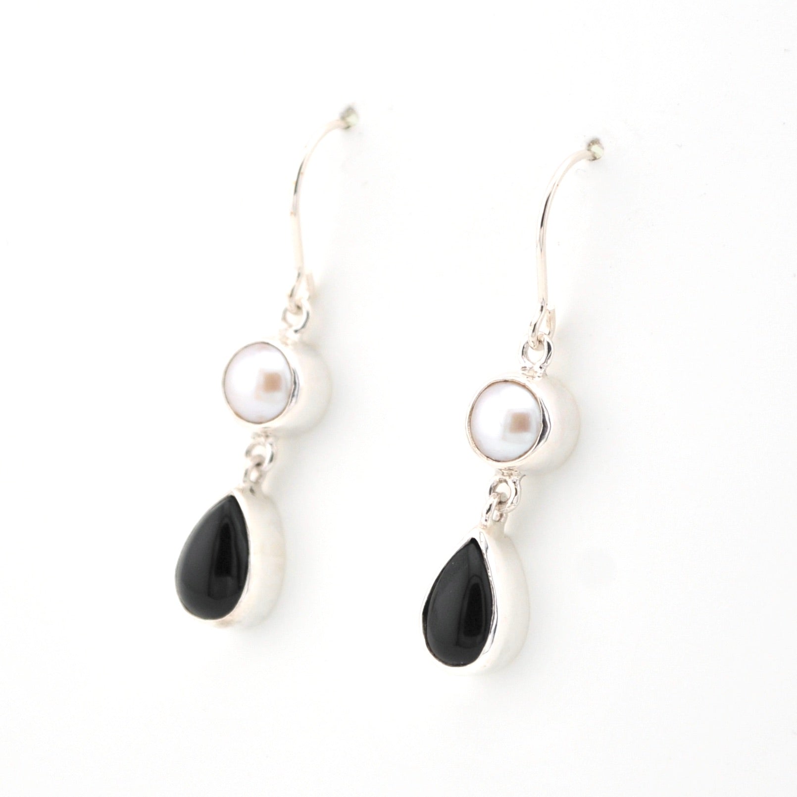 Pair of earrings with black teardrop and pearl elements on a white background