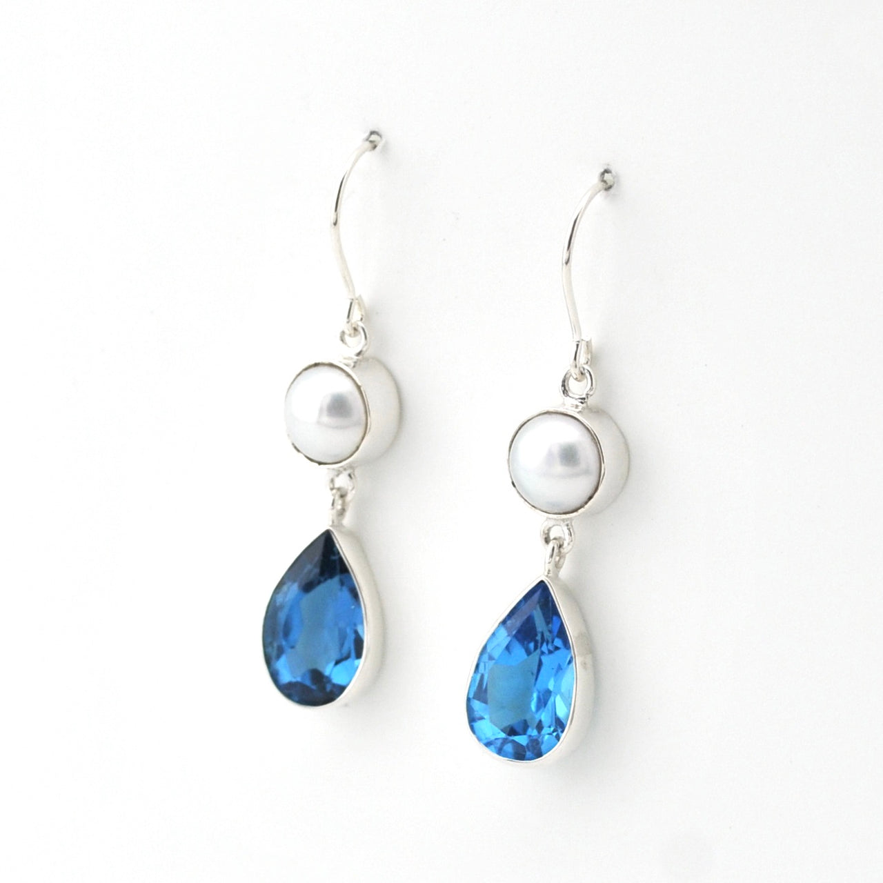 Pair of earrings with blue teardrop stones and pearl-like tops on a white background