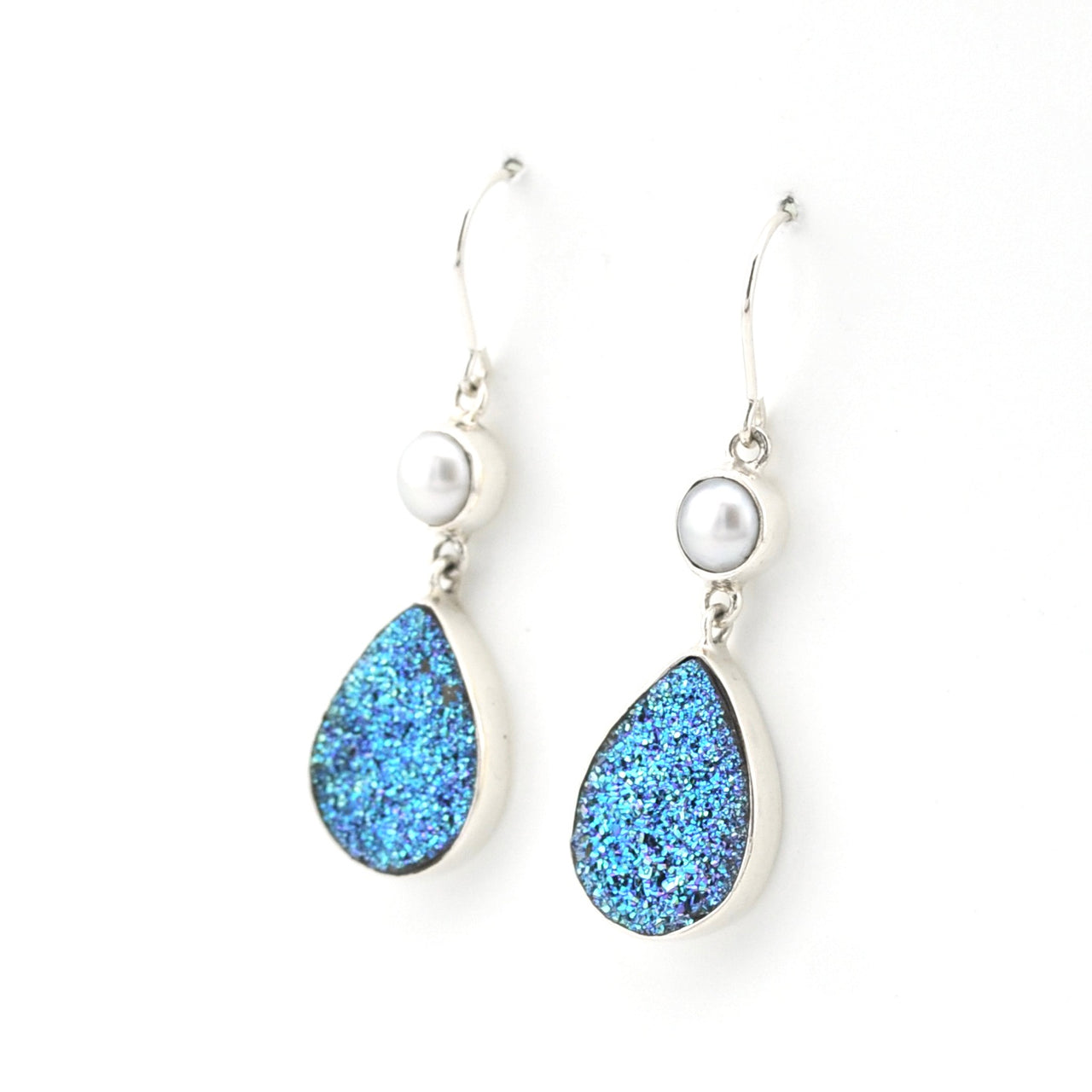 Teardrop-shaped blue earrings with pearl accents on a white background