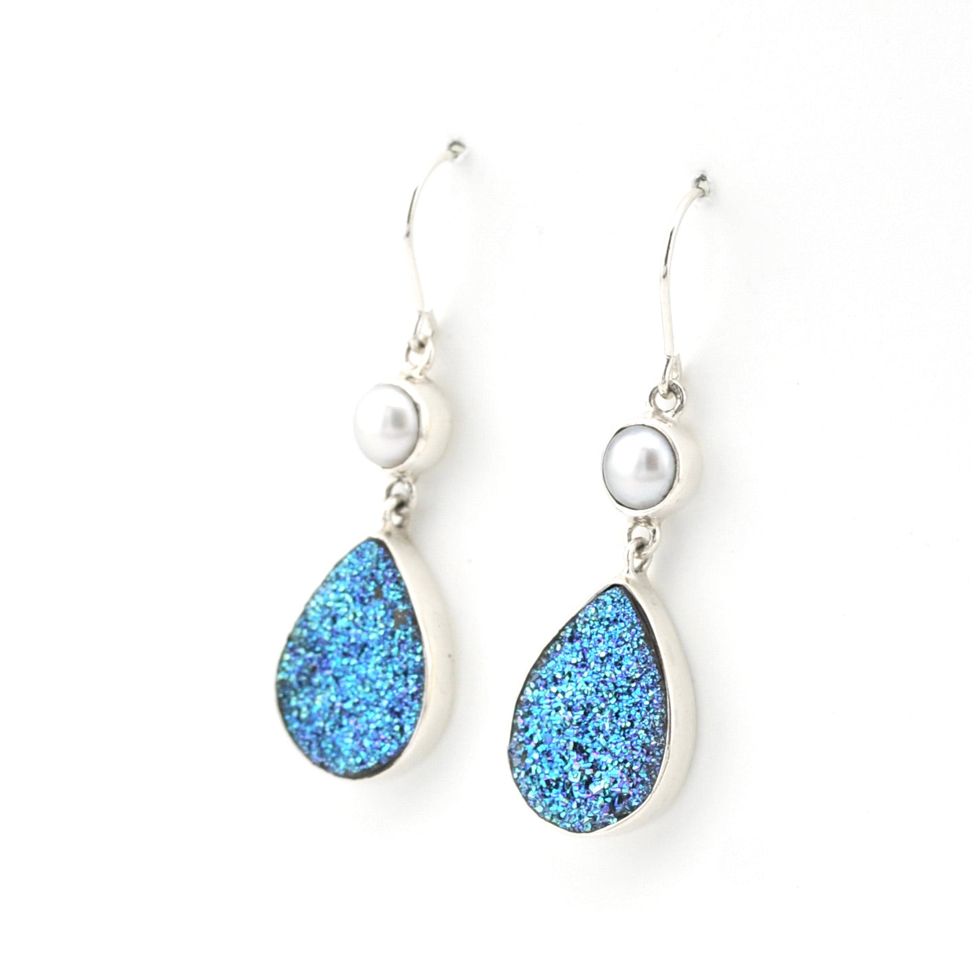 Teardrop-shaped blue earrings with pearl accents on a white background