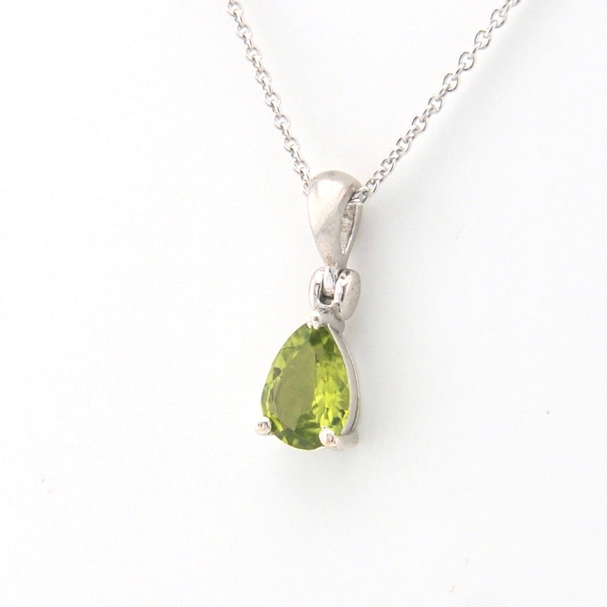 Silver necklace with a green teardrop pendant on a white background