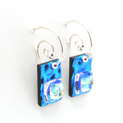 Blue glass earrings on silver hooks against a white background