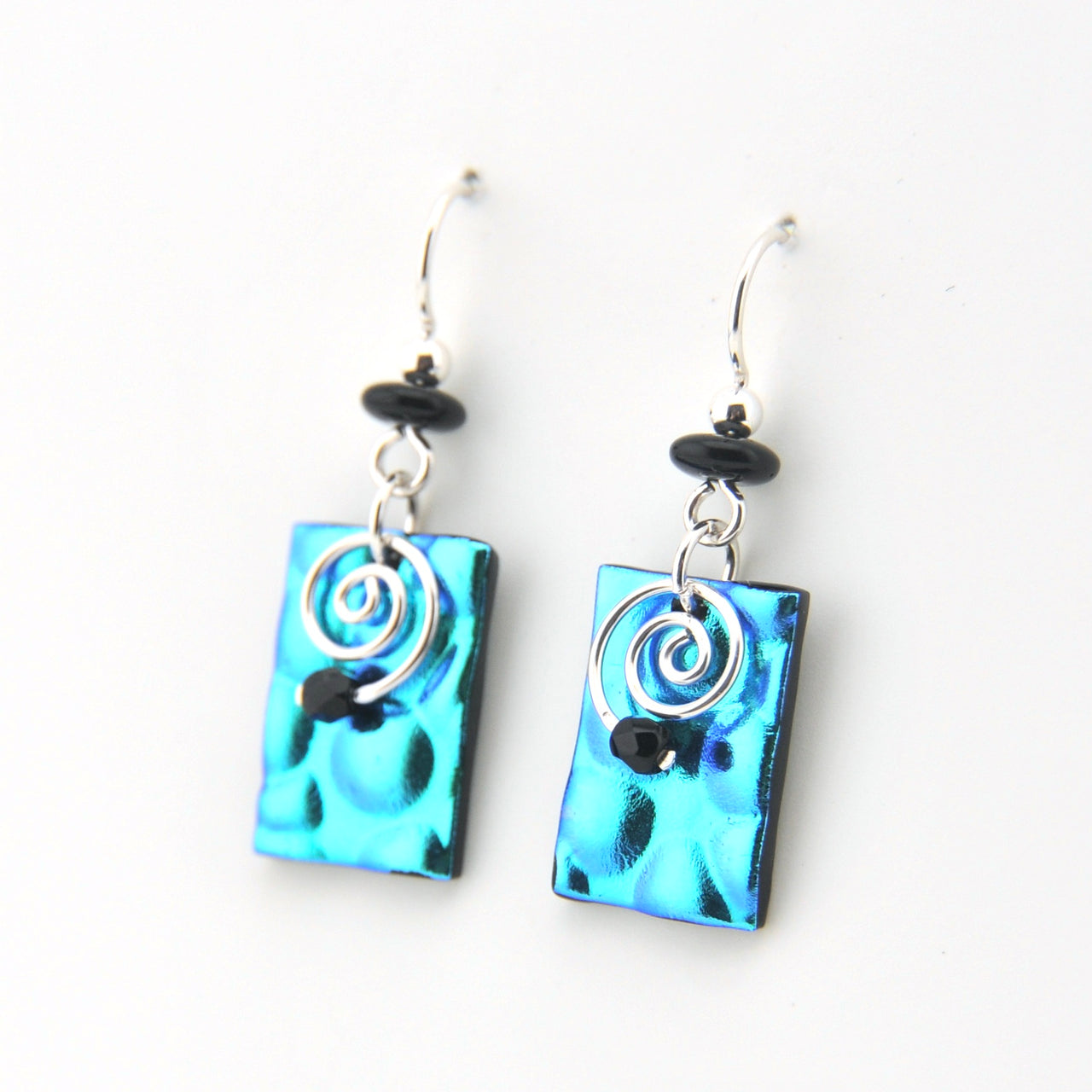 Pair of earrings with blue rectangular panels and silver spiral designs on a white background