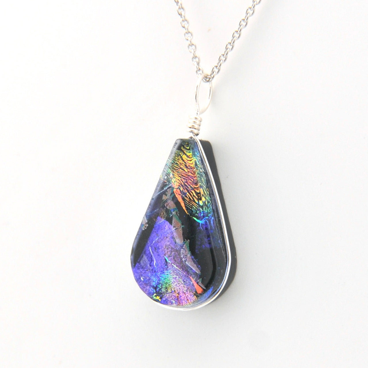 Teardrop-shaped pendant with multicolored iridescent finish on a white background