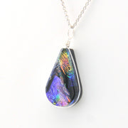 Teardrop-shaped pendant with multicolored iridescent finish on a white background