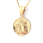 Gold pendant necklace with a detailed design on a white background