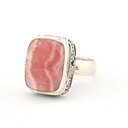 Ring with pink stone and silver band on a white background