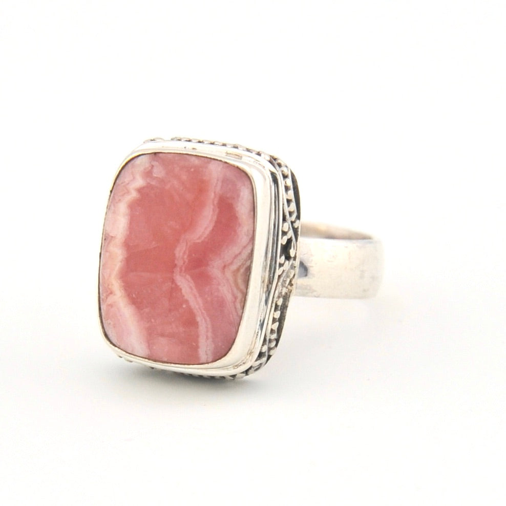 Ring with pink stone and silver band on a white background