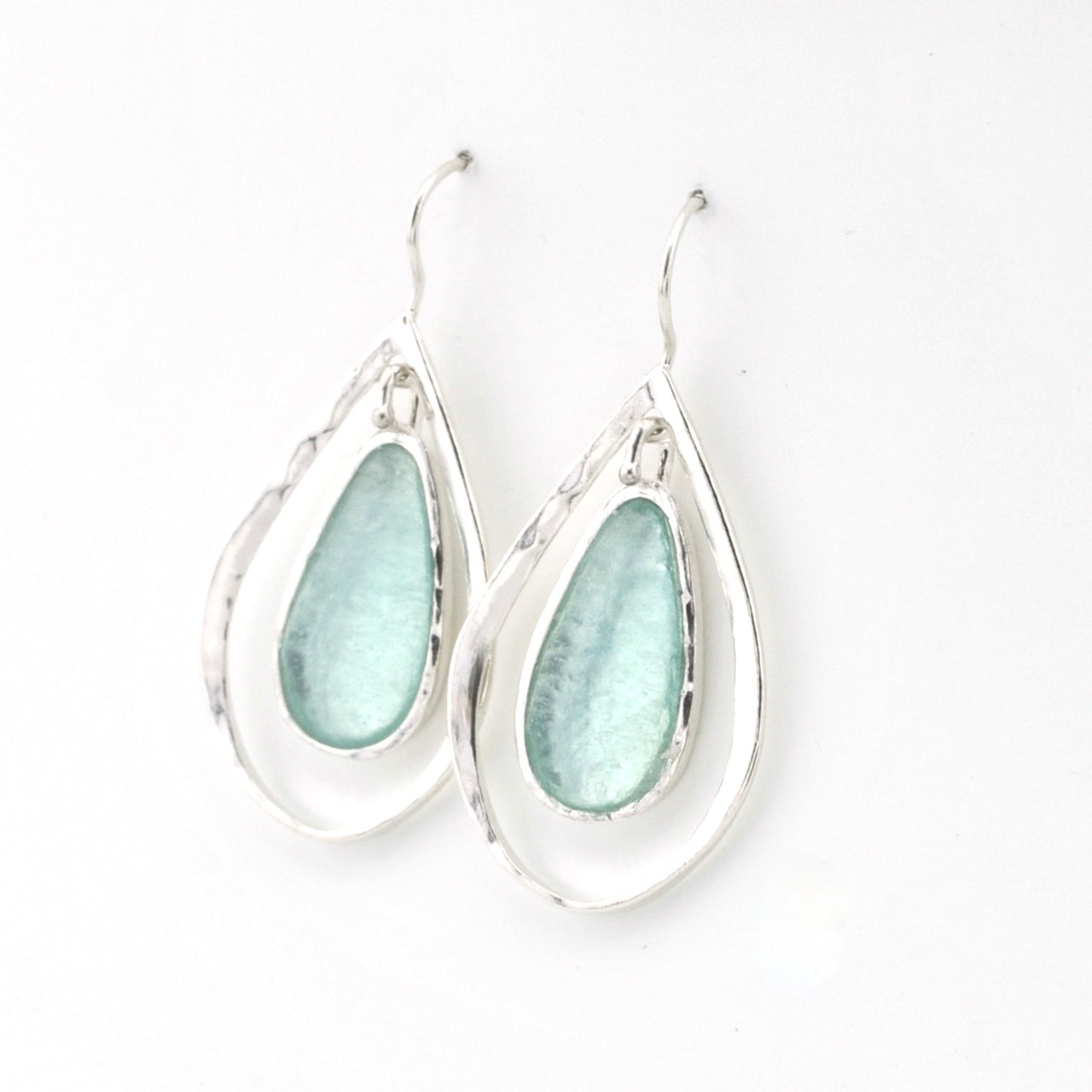 Teardrop-shaped earrings with light blue glass on a white background