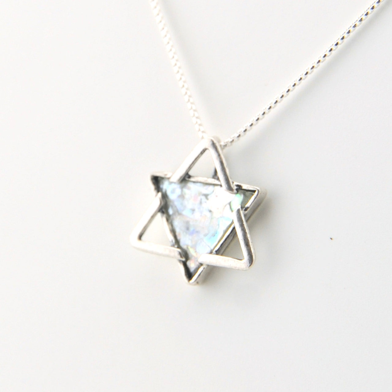 Silver necklace with a star-shaped pendant on a white background