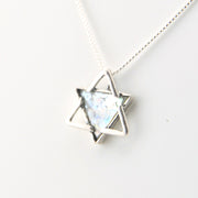 Silver necklace with a star-shaped pendant on a white background