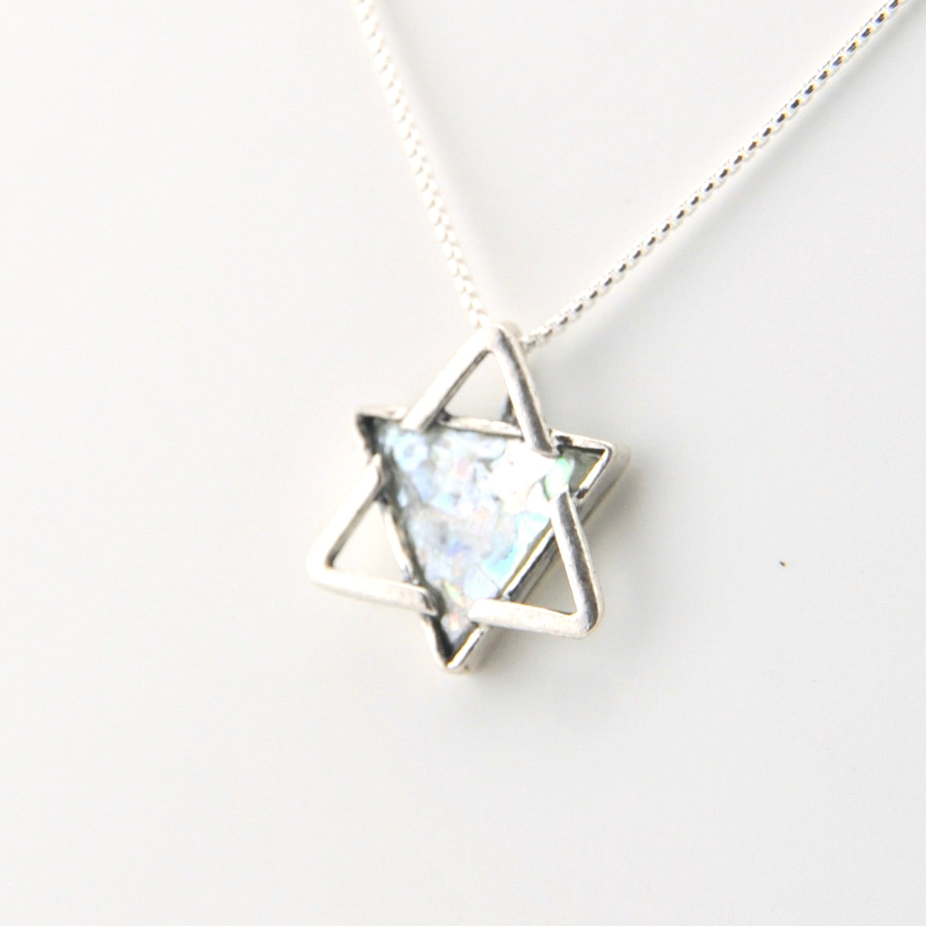 Silver necklace with a star-shaped pendant on a white background