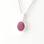 Necklace with a pink oval pendant on a white background