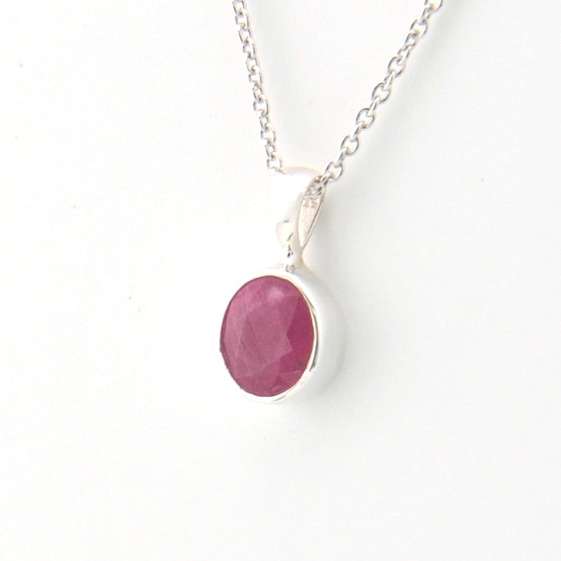 Necklace with a pink oval pendant on a white background