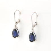 Silver earrings with blue gemstones on a white background