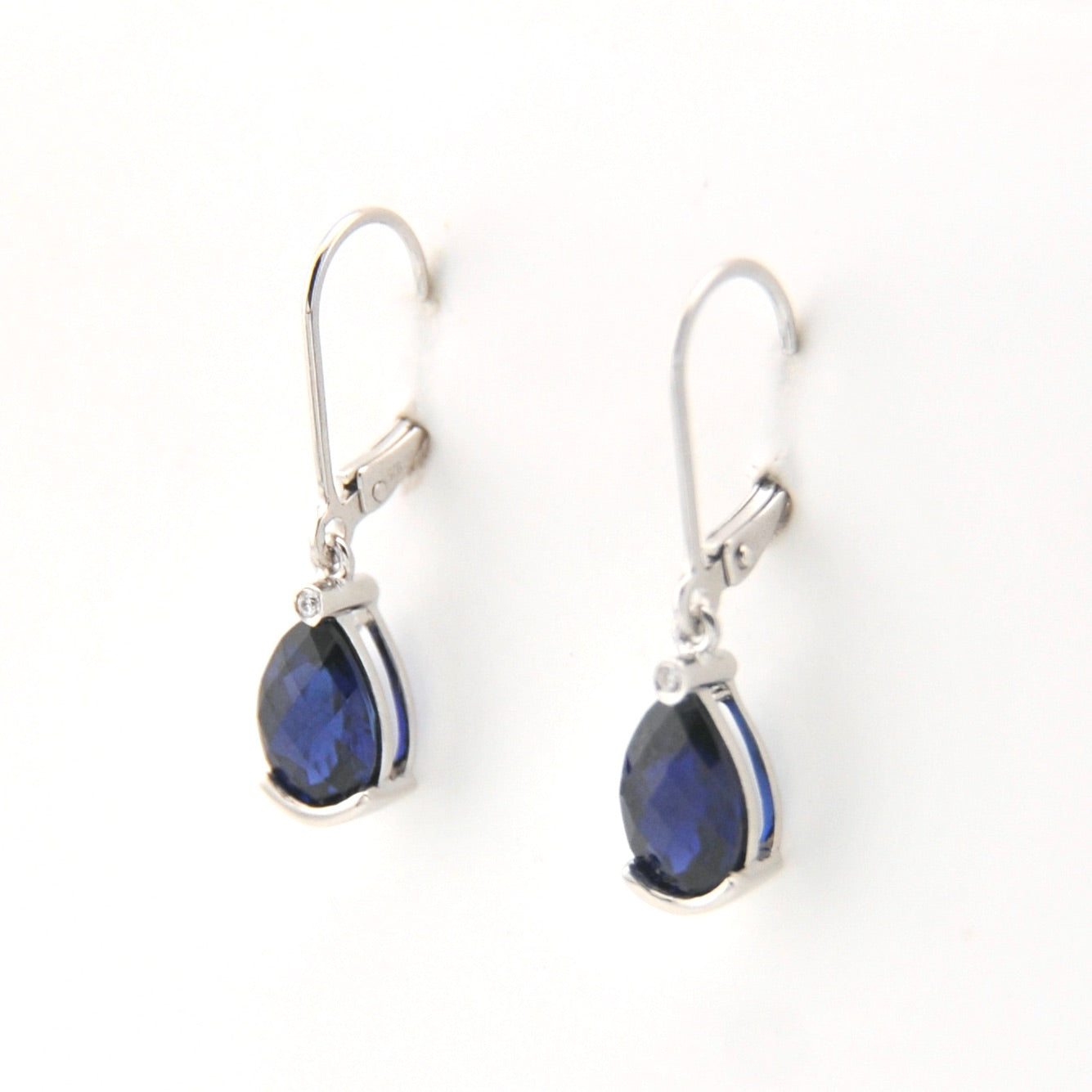 Silver earrings with blue gemstones on a white background