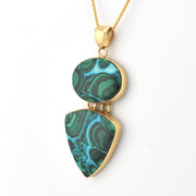 Gold necklace with a green marbled pendant on a white background