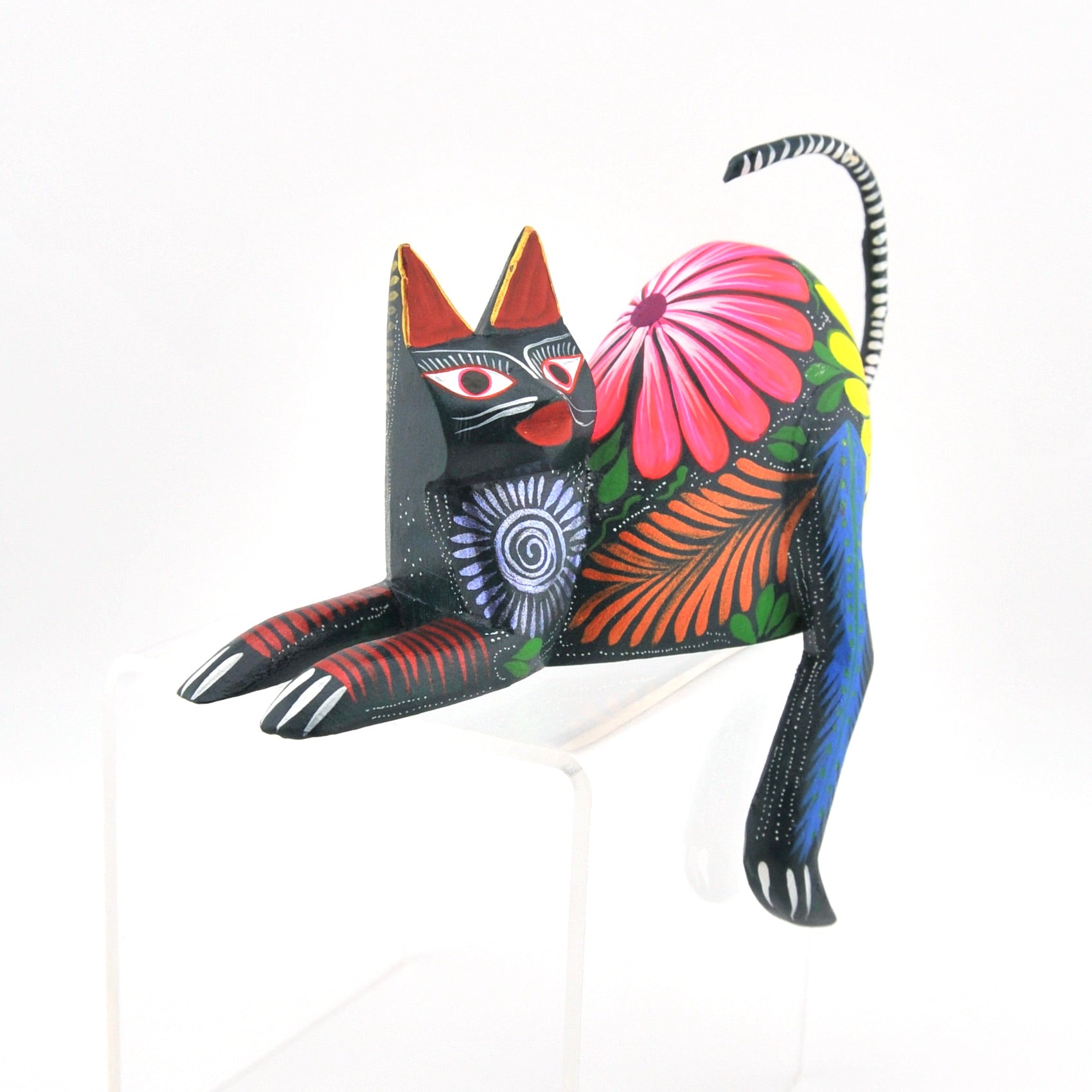 Colorful cat-shaped decorative item with floral patterns on a white background