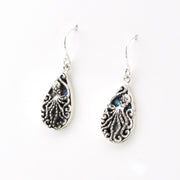 Silver octopus earrings with blue gemstones on a white background