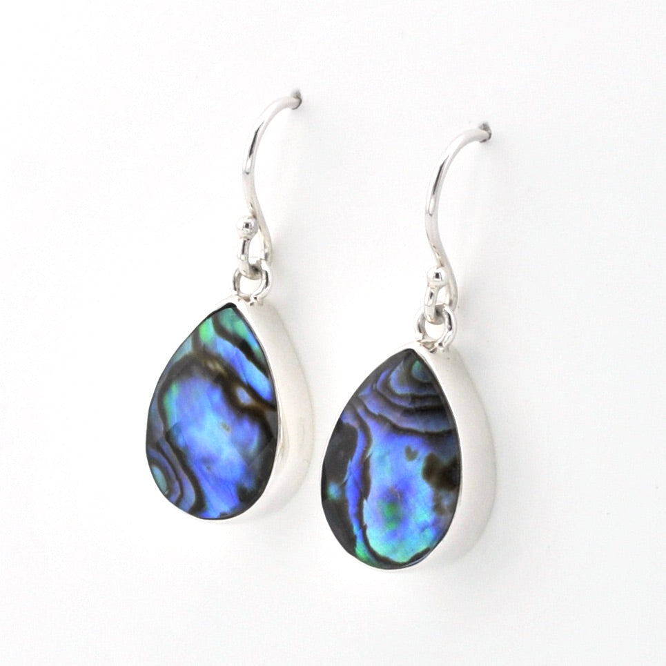 A pair of silver leverback drop earrings featuring teardrop-shaped abalone shell inlays with a shimmering blue, green, and black iridescent pattern, set against a plain white background.