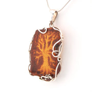 Pendant with brown stone and silver frame on a white background