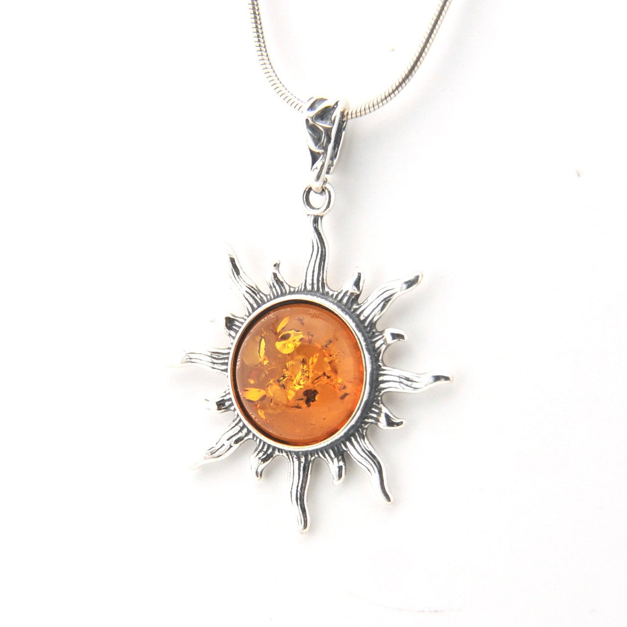 Silver pendant with amber center on a white background