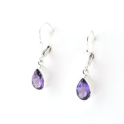 Pair of silver earrings with purple teardrop-shaped gemstones on a white background