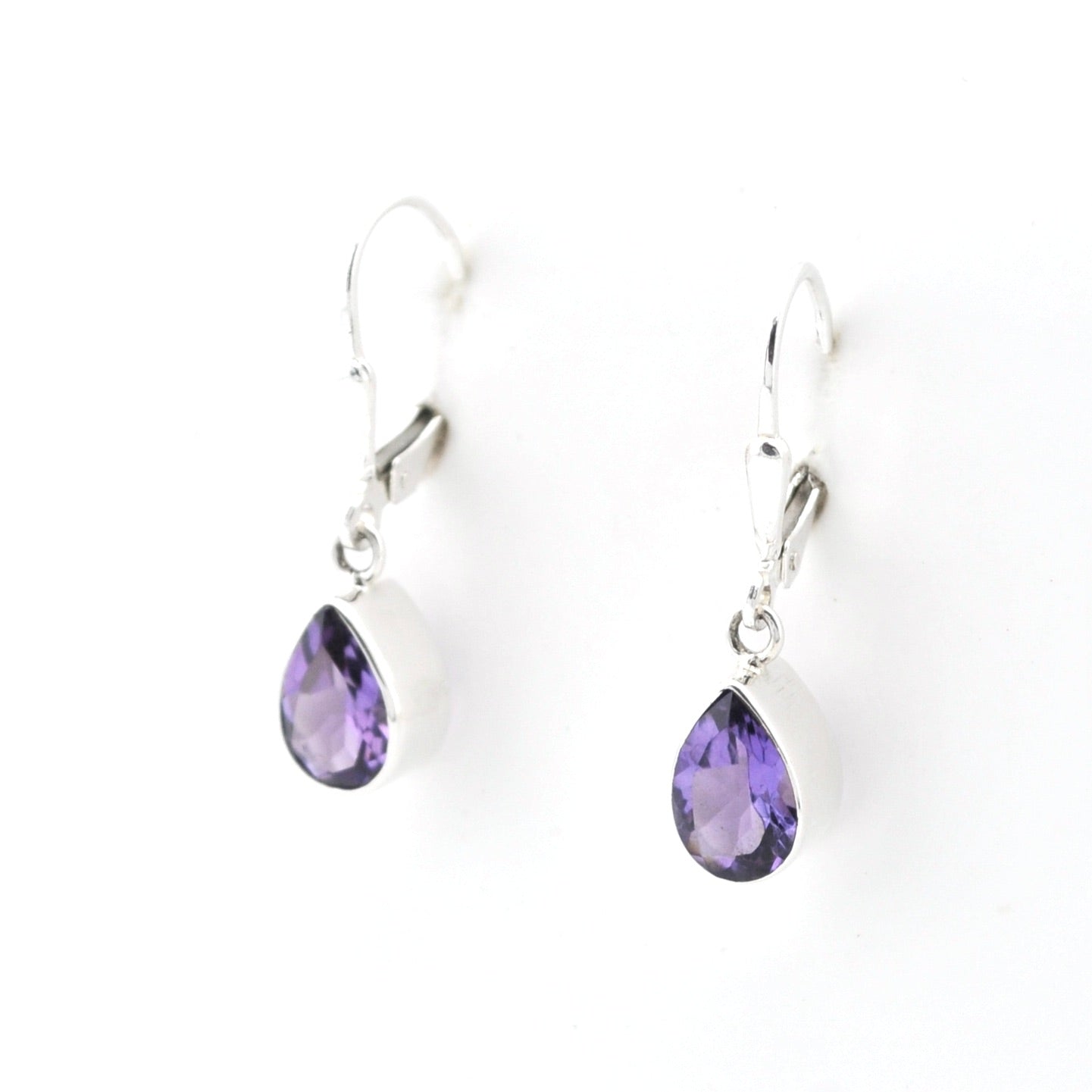 Pair of silver earrings with purple teardrop-shaped gemstones on a white background