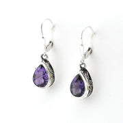 Pair of silver earrings with purple teardrop stones on a white background