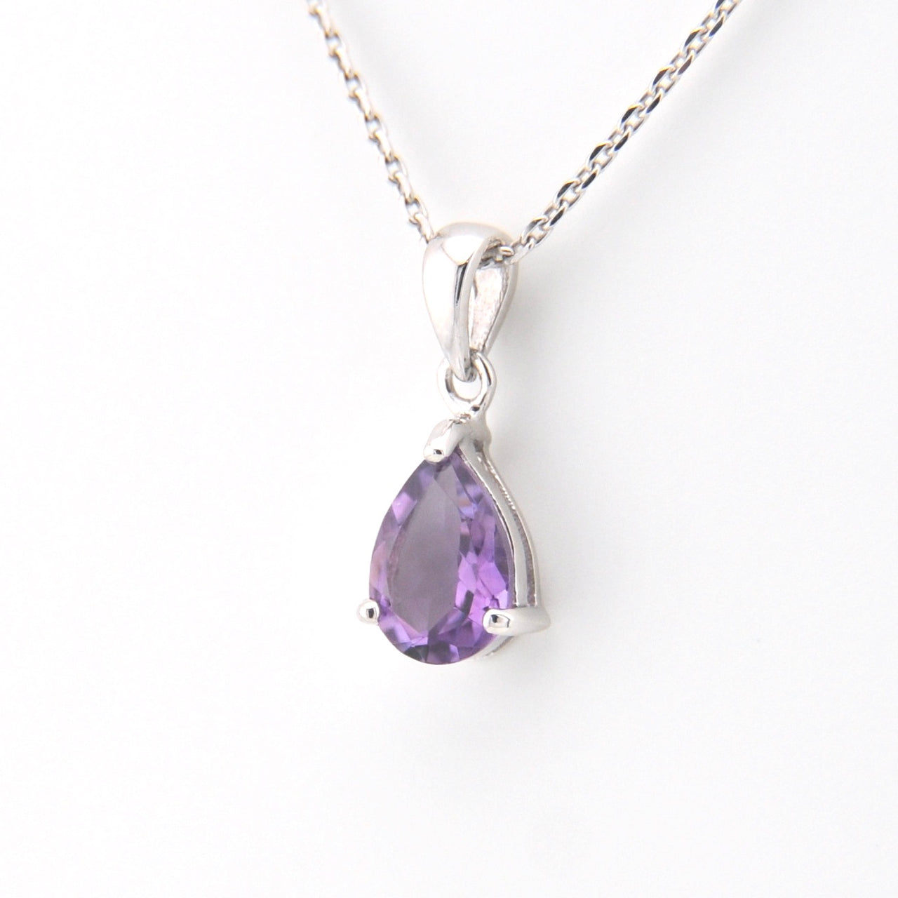 Purple teardrop pendant on a silver chain against a white background