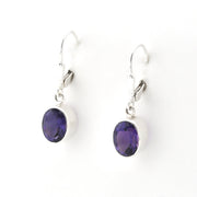 Pair of silver earrings with purple gemstones on a white background