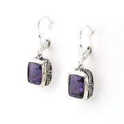 Pair of silver earrings with purple gemstones on a white background