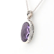 Silver pendant with a purple gemstone on a white background