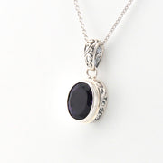Silver pendant with a black stone on a white background