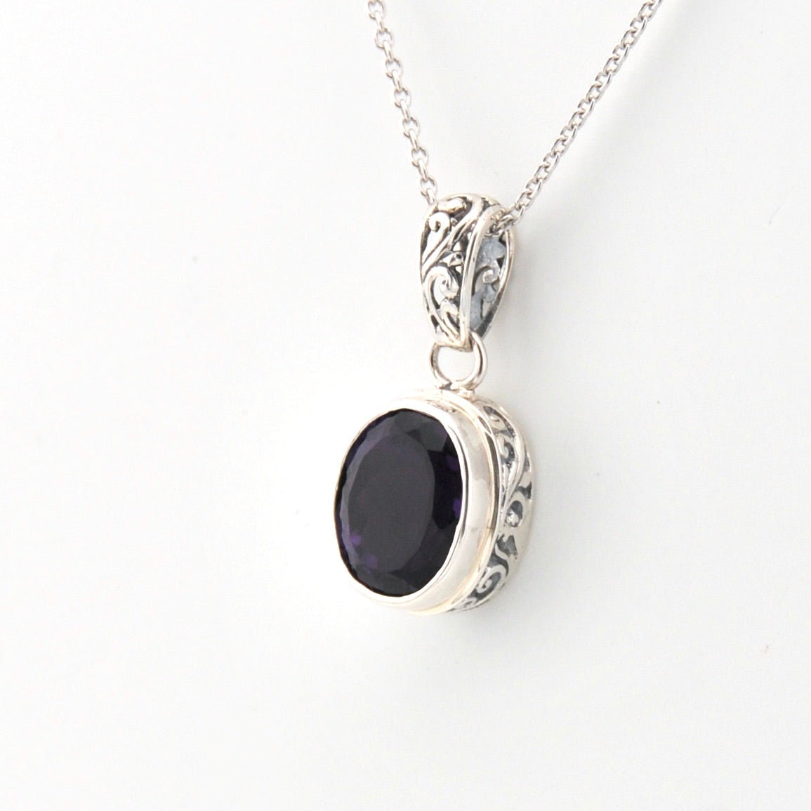 Silver pendant with a black stone on a white background
