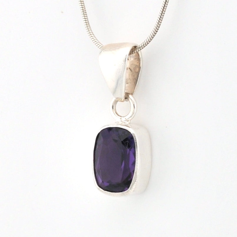Silver pendant with a purple gemstone on a white background