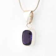 Silver pendant with a purple gemstone on a white background
