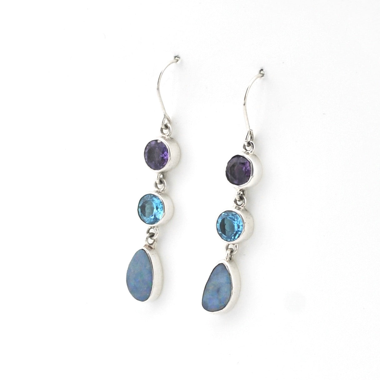 Pair of silver earrings with blue and purple gemstones on a white background